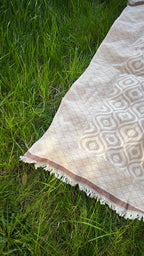 Beige patterned throw blanket with fringes, perfect for cozying up or adding style to your decor.