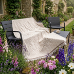 Soft beige geometric patterned throw blanket draped over a garden bench, perfect for outdoor decor.