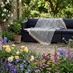 Cozy geometric throw blanket in black and white with fringes, perfect for outdoor seating.