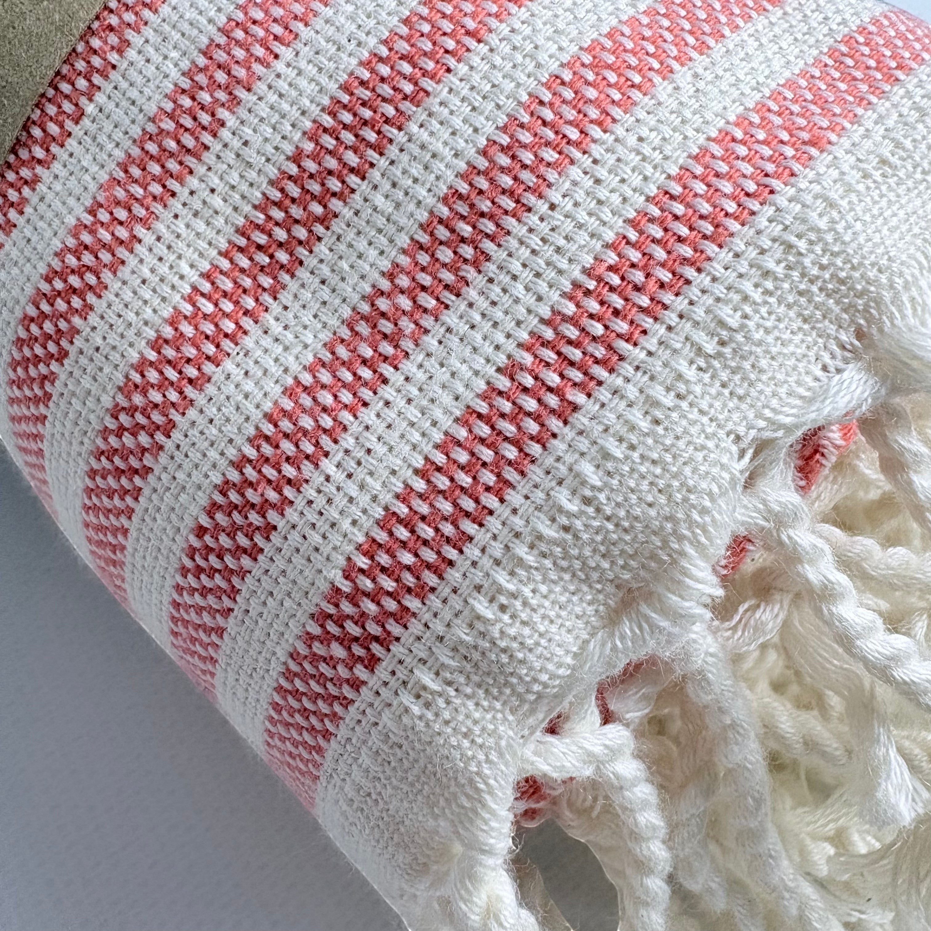 Weavico orange and white striped Turkish beach towel made of 100% cotton with fringe detail.